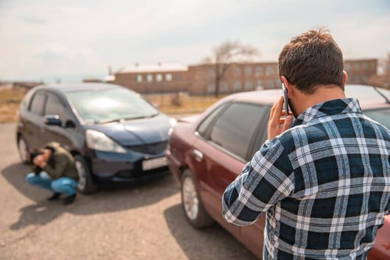 Man on phone after a car accident, illustrating a what to do after car accident checklist.
